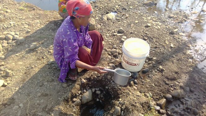 
					Salah satu warga Desa Sumberkare Kecamatan Wonomerto mengambil air dari lubang kerukan tanah, Kamis (28/9/2017).