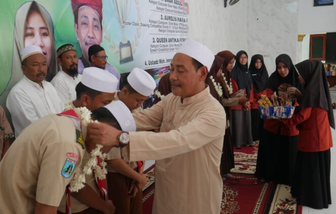 
					Pengasuh PZH Genggong, KH. Moh. Hasan Mutawakkil Alallah mengalungkan bunga kepada santri berprestasi. (Foto : Moh. Rochim) 