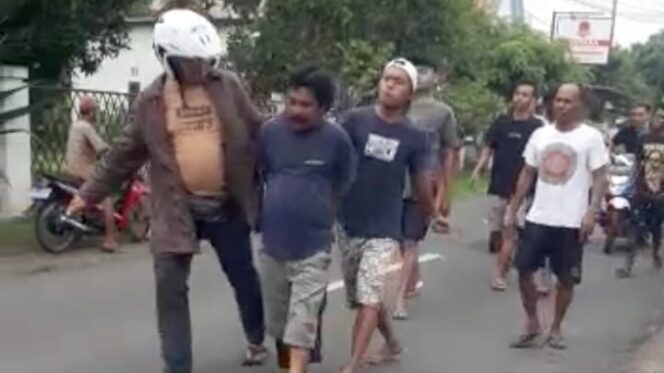 
					TERTANGKAP: Terduga pelaku curanmo saat digelandang anggota kepolisian ke Polsek Kraksaan. (foto: SS video).