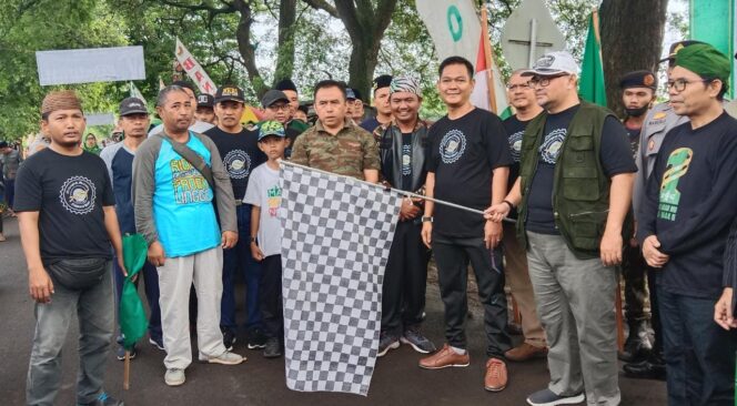
					SOLID: Wabup Timbul (pegang bendera) saat melepas jalan sehat yang digelar PAC Ansor Krejengan. (foto: Ainul Jannah).
