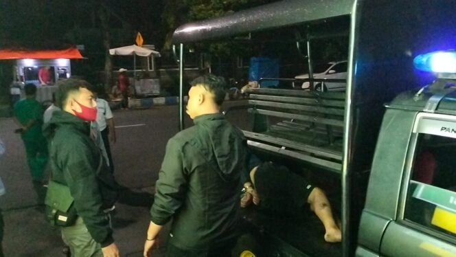 
					DITANGKAP: Pelaku saat berada di atas mobil polisi (foto: Hafidz Rozani).