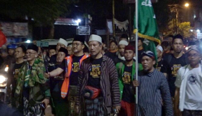 
					BERKHIDMAT: Para kader NU Kab. Pasuruan jalan kaki menuju Gelora Delta Sidoarjo. (Moh. Rois)