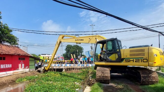 
					Excavator mengangkat sampah dari sungai
