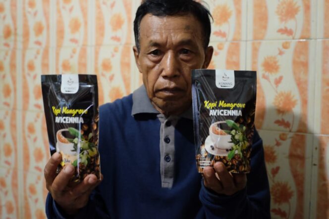 
					Sutarto pembuat kopi mangrove memegang kopi hasil produksinya