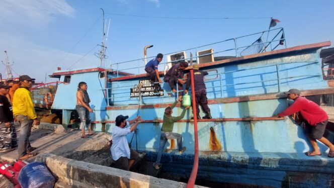 
					Petugas damkar dibantu kru kapal melakukan pemadaman