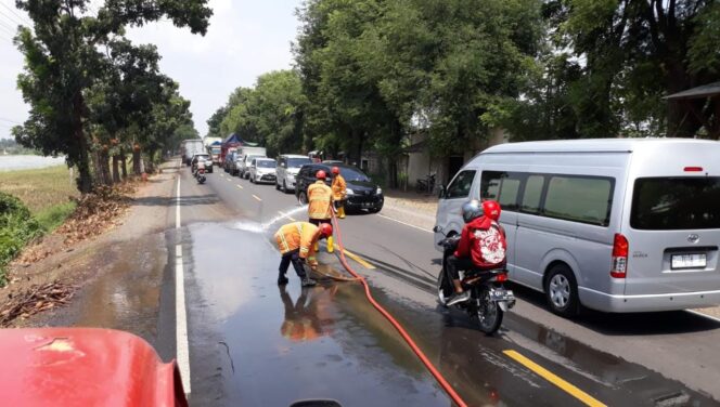 
					MEMBAHAYAKAN: Petugas Damkar Probolinggo saat membersihkan ceceran oli di bahu jalan. (foto: Ainul Jannah)