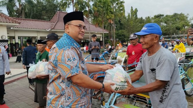 
					Wabup Timbul sedang memberikan paket zakat dan sembako kepada abang becak.