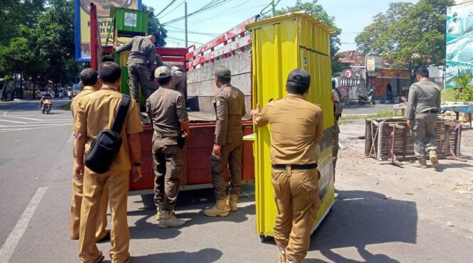 
					DITERTIBKAN: Petugas Satpol PP saat tertibkan gerobak PKL (foto: Istimewa).