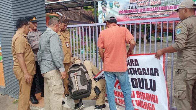 
					Forkopimka Dringu melepas segel yang terpasang di pintu gerbang SDN Kalirejo 2. (Foto: Istimewa)