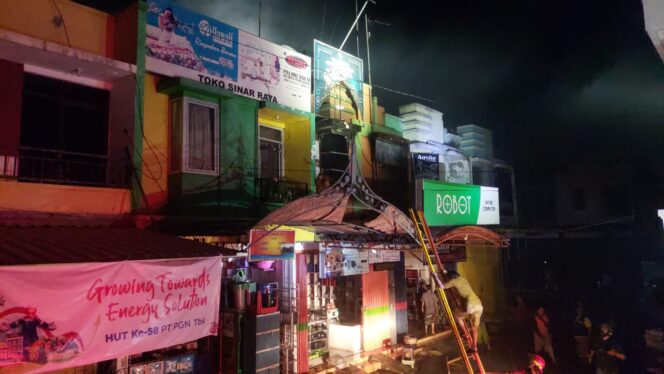 
					Pemadam kebakaran sedang menjinakkan api di ruko.