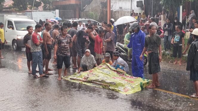 
					Jasad korban kecelakaan ditutupi dengan banner.