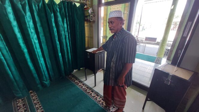 
					DICONGKEL: Marbot masjid, Puji, menunjukkan kotak amal yang dicongkel maling. (foto: Hafiz Rozani)