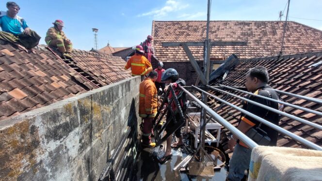 
					Petugas damkar sedang memadamkan api di lantai dua rumah warga.