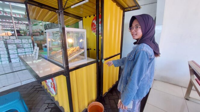 
					Nazma Fahiro penjaga toko franchise menunjukkan gembok kunci kontainer yang dijebol.
