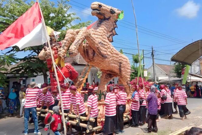 
					KOMPAK: Warga mengarak miniatur Kuda Jingkrak berbahan tahu dalam Festival Banjir Tahu. (Foto: Asmadi)