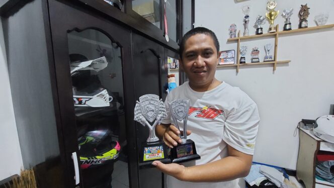 
					Imron Hamzah, ayah M. Nabil menunjukan piala yang diperoleh putranya.