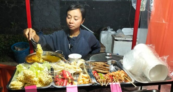 
					LARIS MANIS: Penjual Street Food Daebak, Novita Aditiya, saat melayani pembeli. (foto: Asmadi)