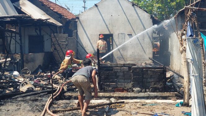 
					TERBAKAR: Petugas Damkar berupaya memadamkan api yang melalap tiga rumah di Desa Curahsawo, Kec. Gending. (foto: Hafis Rozani)