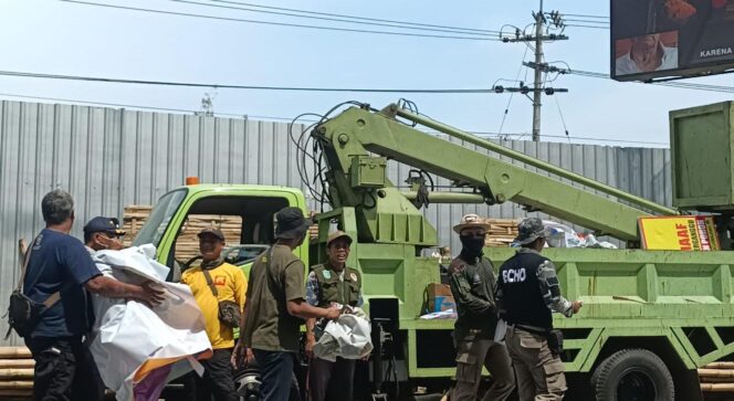 
					STERILISASI: Petugas Satpol PP Lumajang mengangkut baliho liar ke truk. (foto: Asmadi)