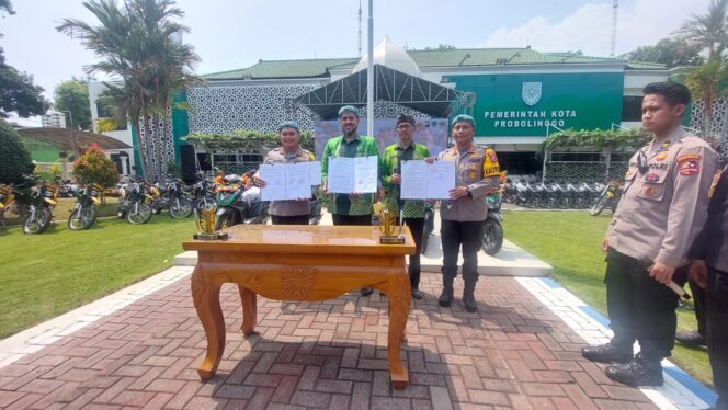 
					SINERGI: Wali Kota Probolinggo dan Kabaharkam Polri menunjukkan berkas penandatanganan hibah motor bagi polisi RW. (foto: Hafiz Rozani).