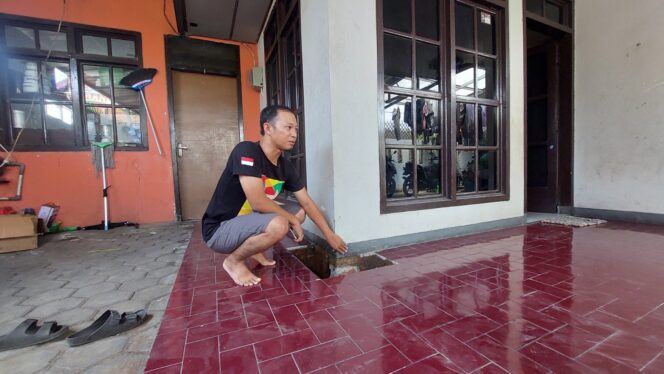 
					Nur Anta Maulana mengecek galian salah satu sudut teras rumahnya yang mengeluarkan hawa panas. (foto: Hafiz Rozani)