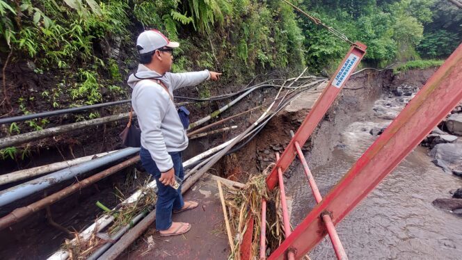 
					TERPUTUS: Warga menunjukan saluran pipa air di akses wisata Air Terjun Madakaripura yang terputus. (foto: Hafiz Rozani).