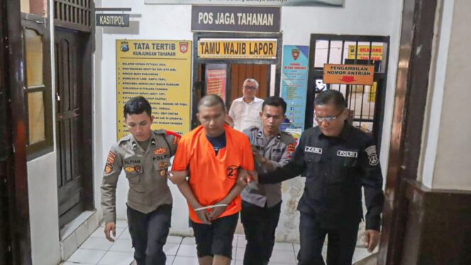 
					DIBEKUK: Tersangka pencabulan diapit anggota Polres Probolinggo Kota (Foto: Istimewa)