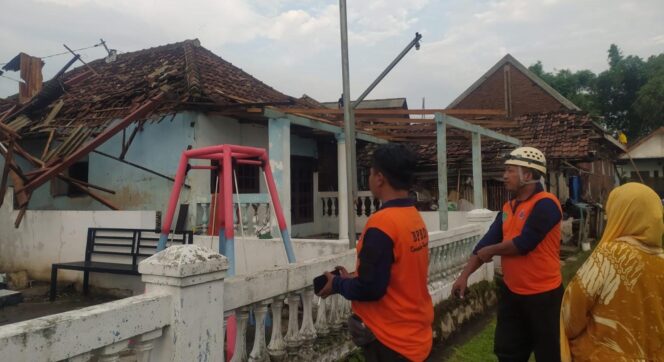 
					RUSAK: Petugas BPBD Kab. Pasuruan membersihkan material kerusakan rumah yang diterjang angin kencang. (foto: Moh. Rois).