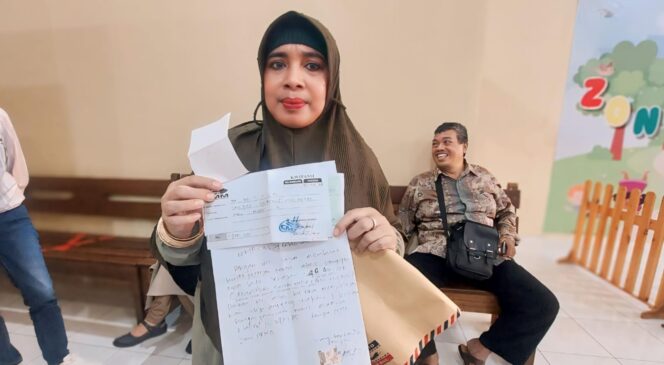
					NGAKU DITIPU: Salah satu korban biro perjalanan umrah, Evi Da'watul Islamiyah, menunjukkan bukti pembayaran biaya umroh di Polres Probolinggo Kota. (foto: Hafiz Rozani)