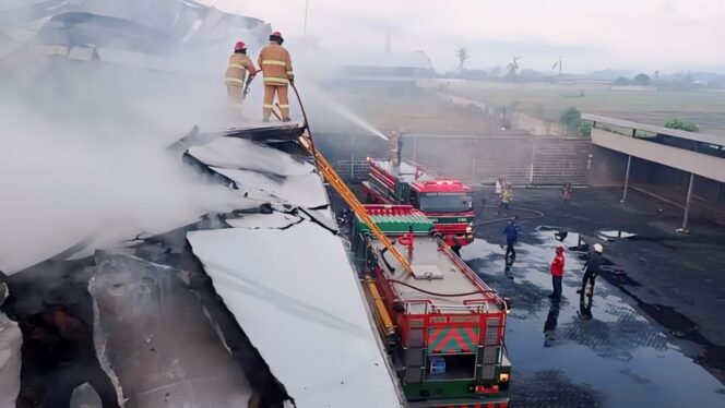 
					KERJA KERAS: Petugas Damkar Kabupaten Lumajang mencoba memadamkan api di GM Plaza dari atap. (foto: Asmadi).