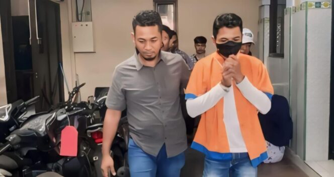 
					DITAHAN: Achmad Koezaini, mantan Kepala Desa Kalisemut, Kecamatan Padang, Kabupaten Lumajang, saat digelandang polisi ke tahanan. (foto: Asmadi).
