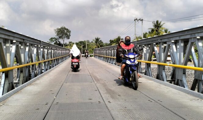
					RAMPUNG: Warga melintas di Jembatan Kloposawit Lumajang, yang sudah bisa dilalui pasca rusak diterjang banjir lahar hujan. (foto: Asmadi).