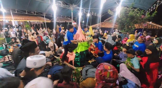 
					REBUTAN: Warga Kelurahan Curahgrinting, Kecamatan Kanigaran, Kabupaten Probolinggo,  berebut gunungan berisi hasil bumi  dalam rangka Grebeg Suro Tahun Baru Islam 1445 H. (foto: Hafiz Rozani).