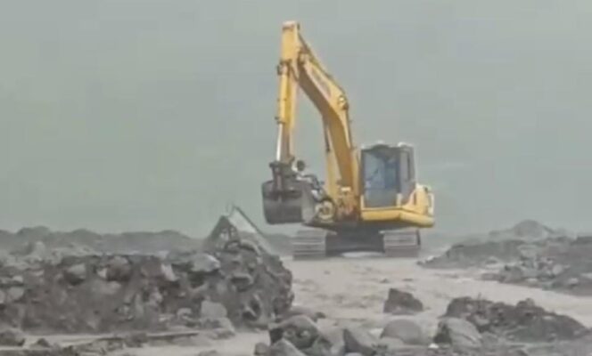 
					Tangkapan layar video saat pemotor dan kendaraannya di Lumajang dievakuasi dengan alat berat.
