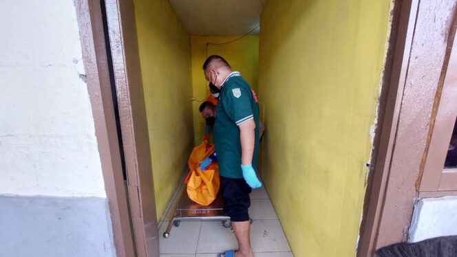 
					EVAKUASI: Petugas ambulans tengah mengevakuasi jenazah korban dari kamar kos ke kamar jenazah. (foto: Hafiz Rozani)
