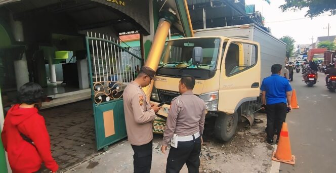 
					Polisi meninjau mobil boks yang menabrak gapura masjid di Kota Pasuruan.