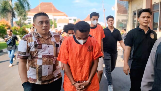 
					DITANGKAP: Kobar (rompi 48) saat digelandang polisi untuk mengikuti pers rilis di Mapolres Probolinggo. (foto: Ali Ya'lu).