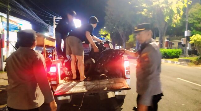 TABRAKAN: Aparat kepolisian saat mengevakuasi motor yang terlibat tabrakan dengan mobil di Kaliwates, Jember. (foto: M. Abd. Rozaq Mubarok).

