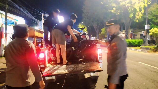 
					TABRAKAN: Aparat kepolisian saat mengevakuasi motor yang terlibat tabrakan dengan mobil di Kaliwates, Jember. (foto: M. Abd. Rozaq Mubarok).

