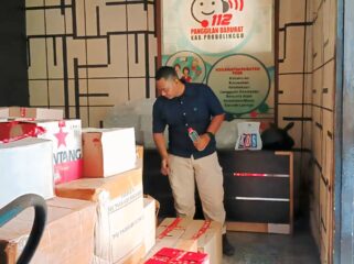 BARANG BUKTI: Petugas Satpol PP Probolinggo mengawasi ribuan botol miras hasil operasi gabungan. (foto: Moch. Rochim).
