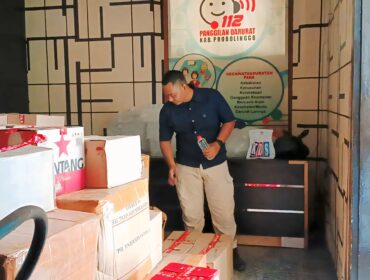 BARANG BUKTI: Petugas Satpol PP Probolinggo mengawasi ribuan botol miras hasil operasi gabungan. (foto: Moch. Rochim).
