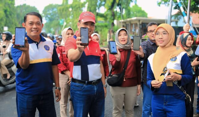 
					NON TUNAI: Wali Kota Probolinggo, dr. Amninuddin (bertopi) dan Kepala Dishub Kota Probolinggo, Agus Effendi menunjukkan transaksi pembayaran parkir non tunai. (Foto: Istimewa)