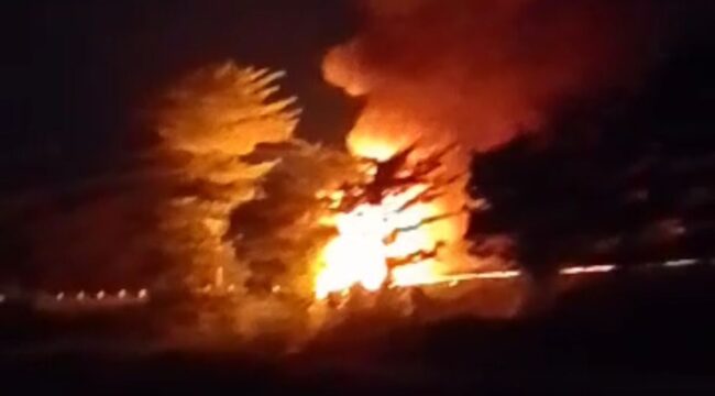 TERBAKAR: Truk muat amunisi milik TNI saat terbakar di Tol Gempol Pasuruan, Senin (5/5/25) malam. (foto: Moh. Rois).