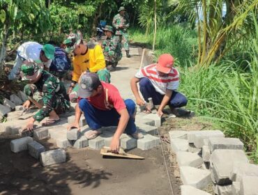 PERBAIKI: Warga bersama personil TNI saat melakukan pavingisasi di Dusun Plalangan, Desa Plalangan, Kecamatan Kalisat, Kab. Jember. (foto: Istimewa)
