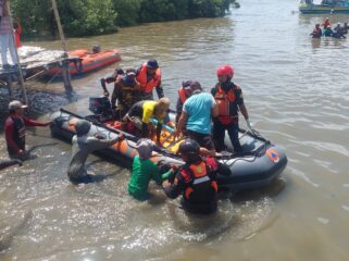 EVAKUASI: Petugas gabungan di Probolinggo saat mengevakuasi jasad korban tenggelam menggunakan perahu karet. (foto: Hafiz Rozani).
