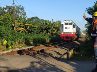 JAGA: Petugas KAI saat menjaga perlintasan sebidang di wilayah Daop 9 Jember selama libur panjang kenaikan Isa Almasih Tahun 2025. (foto: Humas KAI Daop 9 Jember)