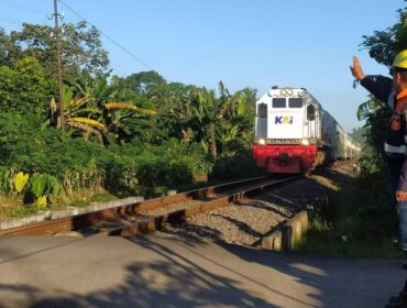 JAGA: Petugas KAI saat menjaga perlintasan sebidang di wilayah Daop 9 Jember selama libur panjang kenaikan Isa Almasih Tahun 2025. (foto: Humas KAI Daop 9 Jember)