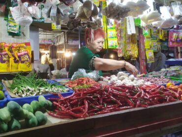 ANJLOK: Salah satu pedagang bahan pokok di Pasar Tanjung Jember, sedang menjual dagangannya. (foto: M. Abd. Rozaq Mubarok).
