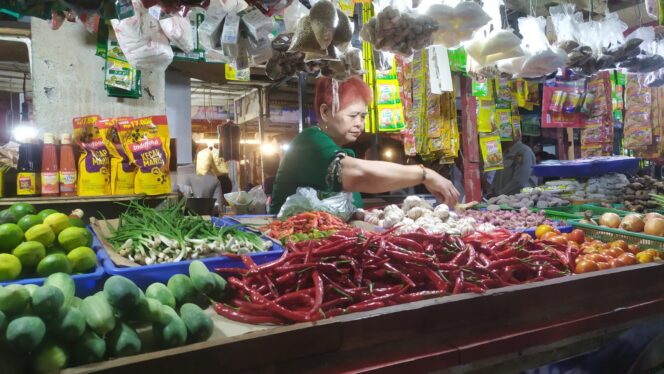 
					ANJLOK: Salah satu pedagang bahan pokok di Pasar Tanjung Jember, sedang menjual dagangannya. (foto: M. Abd. Rozaq Mubarok).
