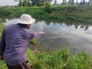 TEWAS: Warga menunjukkan lokasi tewasnya korban di Sungai Brantas, Kota Probolinggo. (foto: Hafiz Rozani)